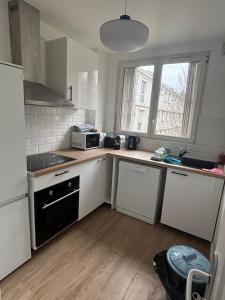 a small kitchen with white appliances and a window at Le Bosquet de Sèvres in Sèvres
