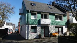 a green and white house on a street at Am Hingstgars in Helgoland