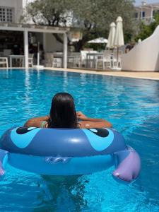 a woman is in a pool in a raft in the water at Lindos Athena in Lindos