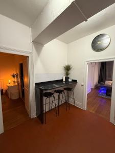 une cuisine avec un comptoir noir et une horloge murale dans l'établissement le logis de la cathédrale, à Auxerre