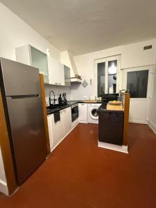 une cuisine avec des armoires blanches et un réfrigérateur en acier inoxydable dans l'établissement le logis de la cathédrale, à Auxerre 18 autres photos