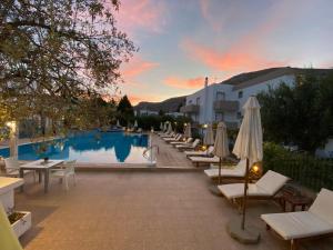 a row of chairs and umbrellas next to a pool at Lindos Athena in Lindos