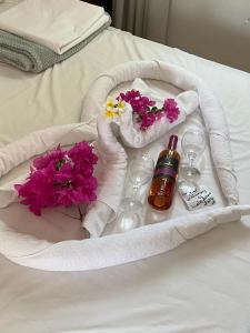 a tray with flowers and wine glasses on a bed at Lindos Athena in Lindos