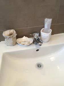 a bathroom sink with a faucet and two dishes on it at B&B Casa Celsi in La Spezia +45 photos
