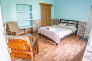 una camera da letto con un letto e una sedia di Hotel Unicorn a Pokhara