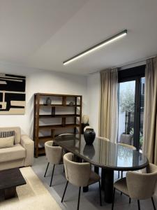 a living room with a glass table and chairs at Casa Amayuma - Málaga Centro Histórico in Málaga +26 photos
