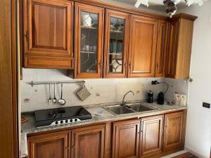 a kitchen with wooden cabinets and a sink at Casa Matilde in Sestu