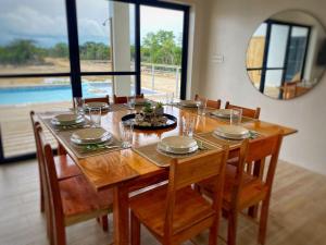 a dining room table with chairs and a mirror at Modern Luxe Villa With Pool and Steps to Secret Beach Sleeps 8 in San Pedro