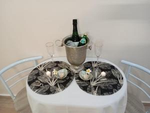 a table with two glasses and a bottle of wine at Love & Lagon - suite romantique & spa privé in Saint-Paul