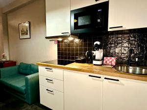 a kitchen with a counter with a sink and a microwave at Luxury Suites Diamond by Rikas Hotels in Antwerp