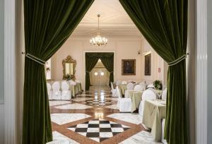 une salle de banquet avec des tables blanches et des rideaux verts dans l'établissement Grand Hotel Terme, à Riolo Terme