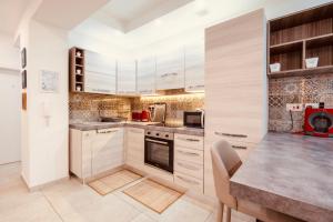 a kitchen with white cabinets and a table in it at LA 88 Boutique in St Paul's Bay