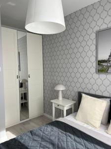 a bedroom with a bed and a white wall at Apartament City Rent Płock 2 in Płock