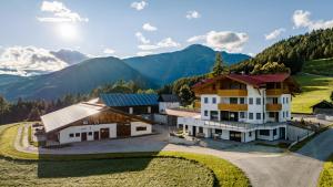 an aerial view of a house with mountains in the background at Forchnerhof Nature & Mountain View Apartments in Terento