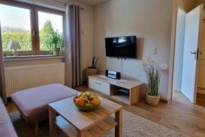 a living room with a television and a bowl of fruit on a table at Ferienwohnung Wagner 4 Sterne in Neef