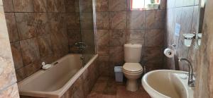 a bathroom with a toilet and a tub and a sink at Field and Stream in Dullstroom +73 photos