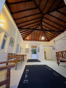 a large room with wooden ceilings and tables and benches at Blue Kite Retreat in Kalpitiya