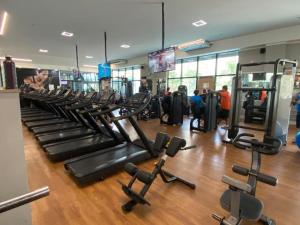 a gym with rows of treadmills and machines at Flat na Barra da Tijuca - Premium - Com Cozinha, Microondas, Estacionamento, Balsa para Praia, Academia, Muito lindo, Confortável e Aconchegante in Rio de Janeiro