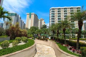 a walkway in a park with palm trees and buildings at Flat na Barra da Tijuca - Premium - Com Cozinha, Microondas, Estacionamento, Balsa para Praia, Academia, Muito lindo, Confortável e Aconchegante in Rio de Janeiro