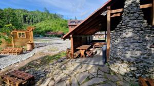 a log cabin with a picnic table and a stone fireplace at Chata vo Vyhnanej - Terchová in Terchová +29 photos