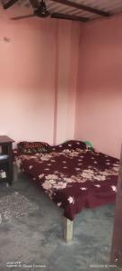 a bedroom with a bed with a brown comforter at Amit Homestay in Khatīma