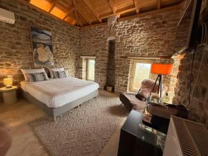 a bedroom with a bed and a stone wall at Εn Kanalion in Kanália