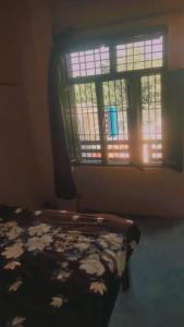 a bedroom with a bed in front of a window at Amit Homestay in Khatīma