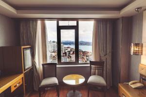 a room with a table and chairs and a large window at Style Star Hotel Cihangir in Istanbul