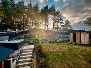 a backyard with a jacuzzi tub and a rock wall at Chata ARMA in Vrbov