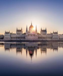 a parliament building with the sun setting behind it at Buda Blue in Budapest