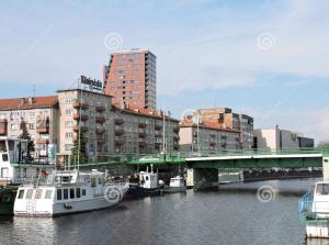 a city with buildings and a bridge and boats at Central Apartament in Klaipėda