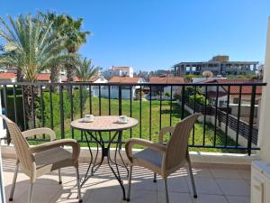 eine Terrasse mit Tisch und Stühlen auf einem Balkon in der Unterkunft Apartment in Kato Pafos & 10 min to Venus beach in Paphos City