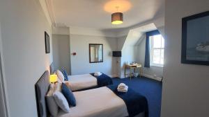 a hotel room with two beds and a window at Royal Temple Yacht Club in Ramsgate