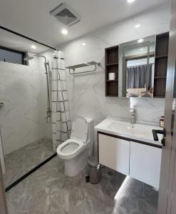 a white bathroom with a toilet and a sink at Affordable Luxury Rooms with Pool, Gym and Office Space in Kigali
