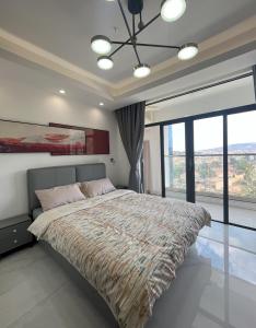 a bedroom with a large bed with a large window at Affordable Luxury Rooms with Pool, Gym and Office Space in Kigali +22 photos