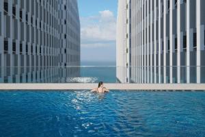 a woman sitting in a swimming pool in a building at APEC MANDANA CHAM BAY Mũi Né in Ấp Thiẹn Ái +4 photos