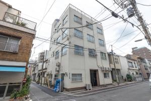 un edificio blanco al costado de una calle en Minowa Sta Direct to Ueno, en Tokio