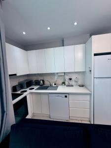 eine weiße Küche mit weißen Schränken und Geräten in der Unterkunft Apartmen in Alanya in the city center by the sea in Alanya + 26 Fotos