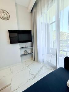 ein Wohnzimmer mit einem TV und einem großen Fenster in der Unterkunft Apartmen in Alanya in the city center by the sea in Alanya