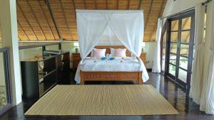 a bedroom with a bed with a canopy at Villa Terang Bulan - luxury private beachfront villa in Pengastulan +44 photos