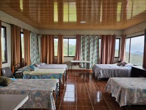 a room with three beds and windows at CreaDora Hotel & Agrotourism Farm in La Estrella