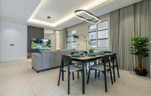 a dining room with a table and chairs and a couch at شقة بتصميم انيق مقابل الافنيوز d11 in Riyadh