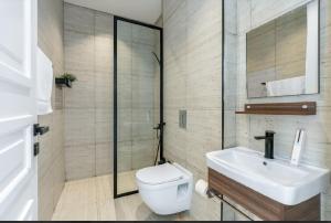 a bathroom with a white toilet and a sink at شقة بتصميم انيق مقابل الافنيوز d11 in Riyadh +26 photos