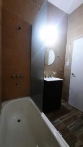 een badkamer met een ligbad en een wastafel bij Solano House in Termas de Río Hondo +6 foto's