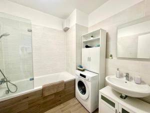 a bathroom with a sink and a washing machine at BudaBright 192 II FreeParking in Budapest