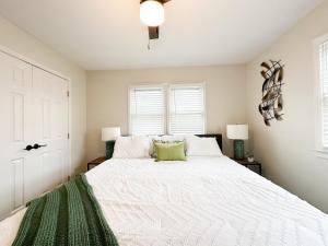 1 dormitorio con 1 cama blanca grande con detalles verdes en Legacy Trail Getaway, en Lexington