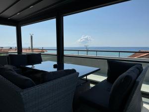a balcony with chairs and a table and the ocean at Laki Hotel in Nea Plagia