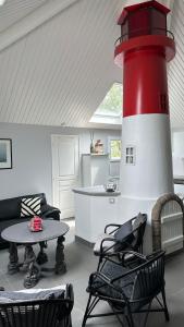 una sala de estar con un faro rojo y blanco en La Louisine séjours du samedi au samedi, en Séné