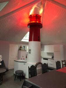 un faro rojo y blanco en una cocina con mesa en La Louisine séjours du samedi au samedi, en Séné 26 fotos más