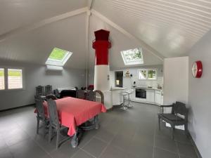 una sala de estar con una mesa y una boca de incendios roja y blanca en La Louisine séjours du samedi au samedi, en Séné